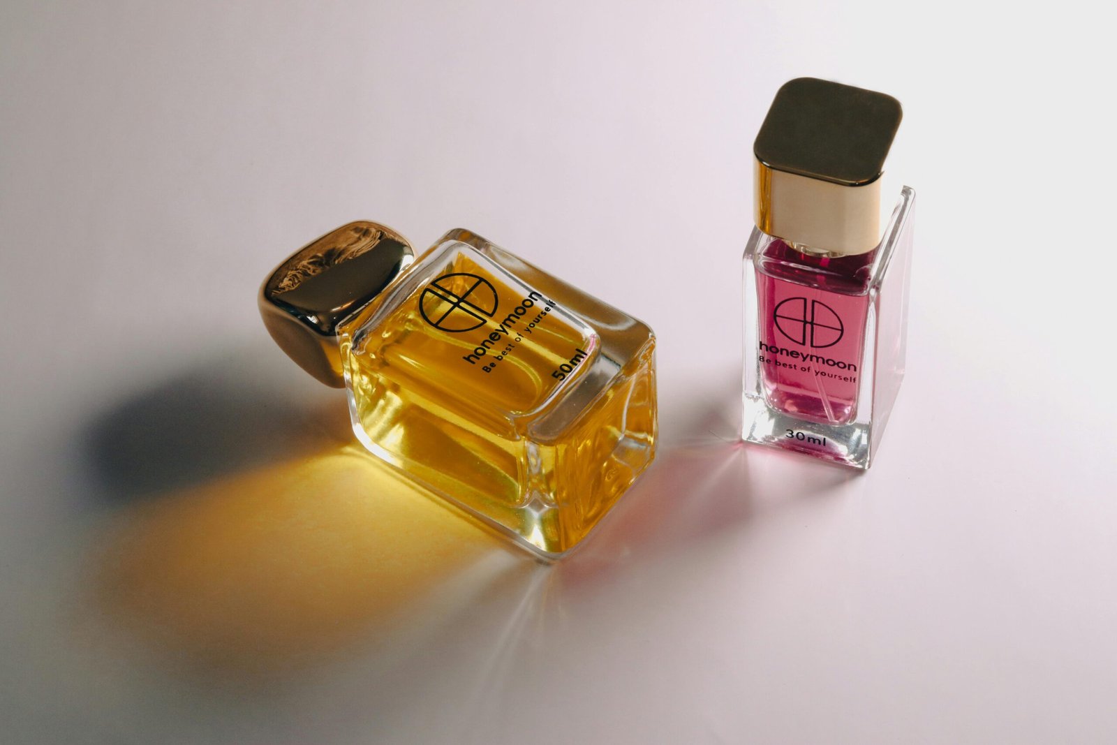 Close-up of elegant glass perfume bottles on a white surface showcasing luxury scents.