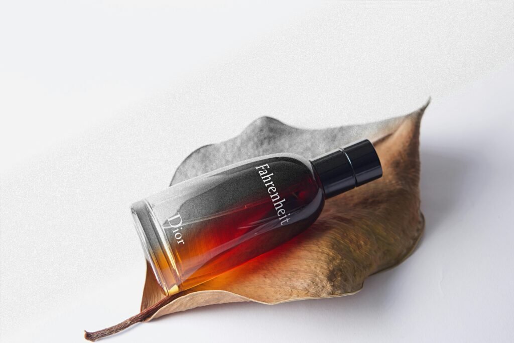 Elegant Dior Fahrenheit perfume bottle displayed artfully on a dried leaf.